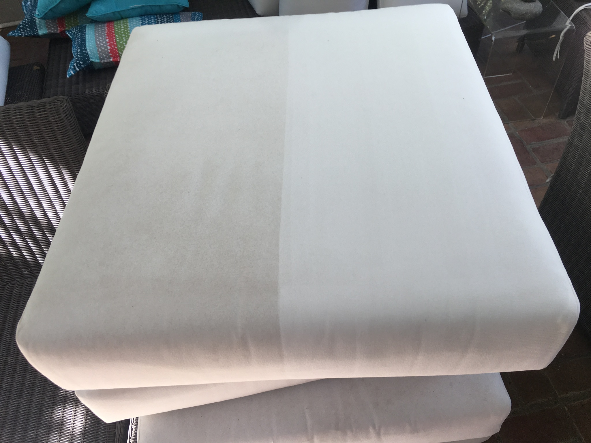 White ottoman half cleaned by Jesse showing dramatic before-and-after transformation